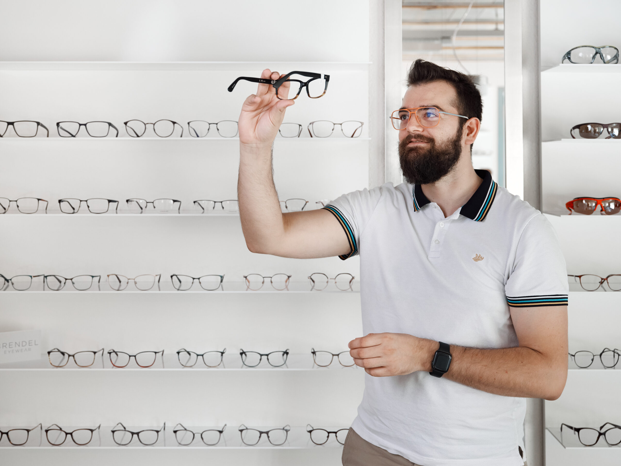 Simon Schärer, Inhaber des Brillenwerks , schaut sich eine Brillenfassung an