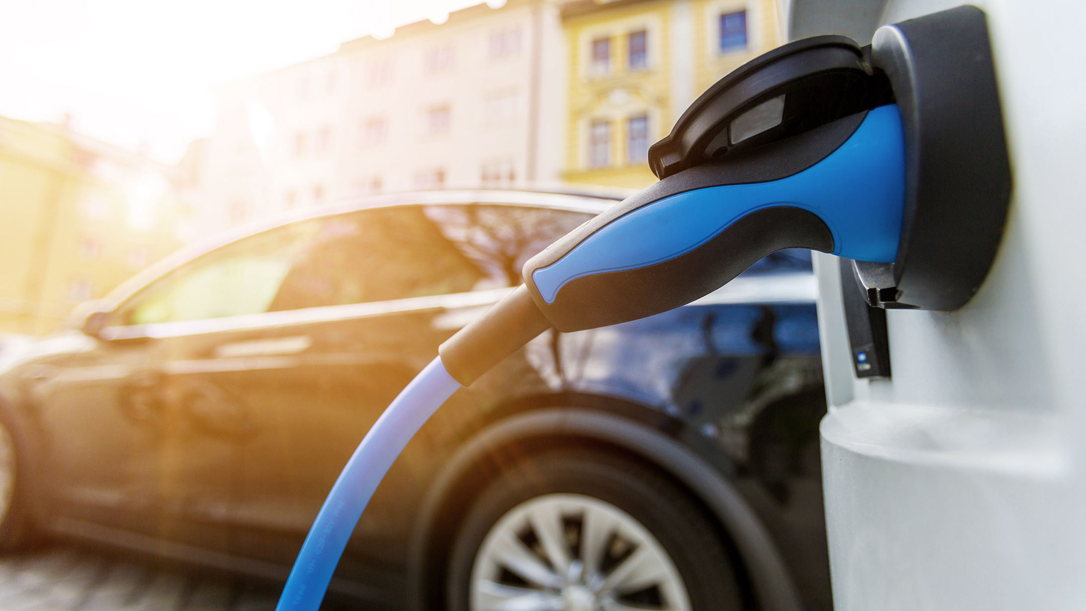 Elektroauto wird in einer Strasse an der Ladestation aufgeladen.