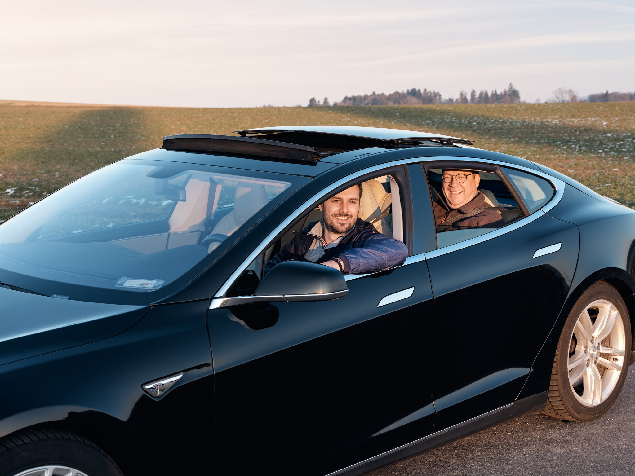 Mieter Fabian Mende und sein Vermieter Christian Huber sitzen zufrieden im Elektroauto