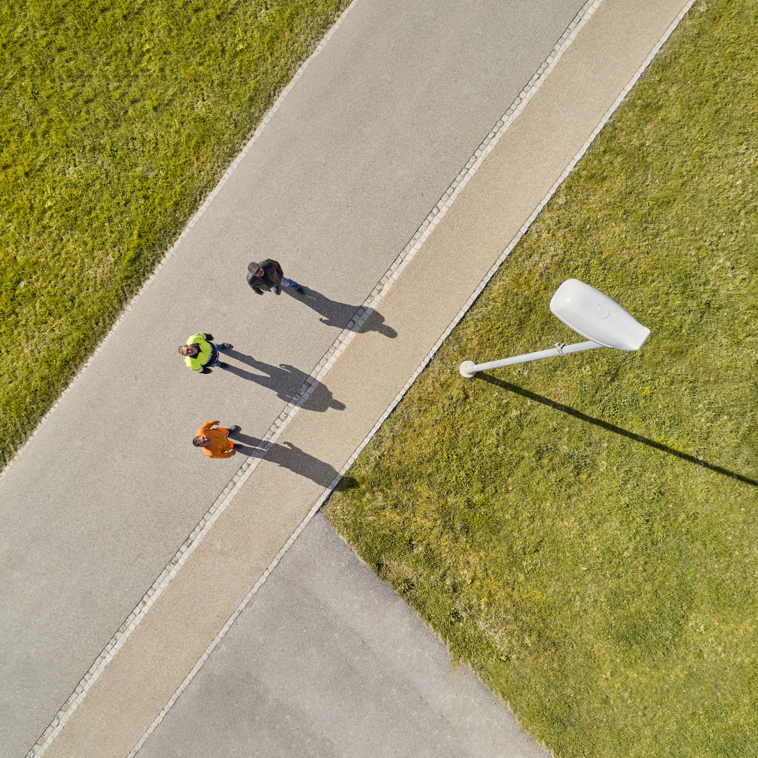 Michael Müller, Projektleiter Netze bei Elektra, steht mit zwei Gemeindemitarbeitenden auf der Strasse und schaut einem Kandelaber empor. Die Elektra bietet Gemeinden Dienstleistungen für die öffentliche Beleuchtung an.