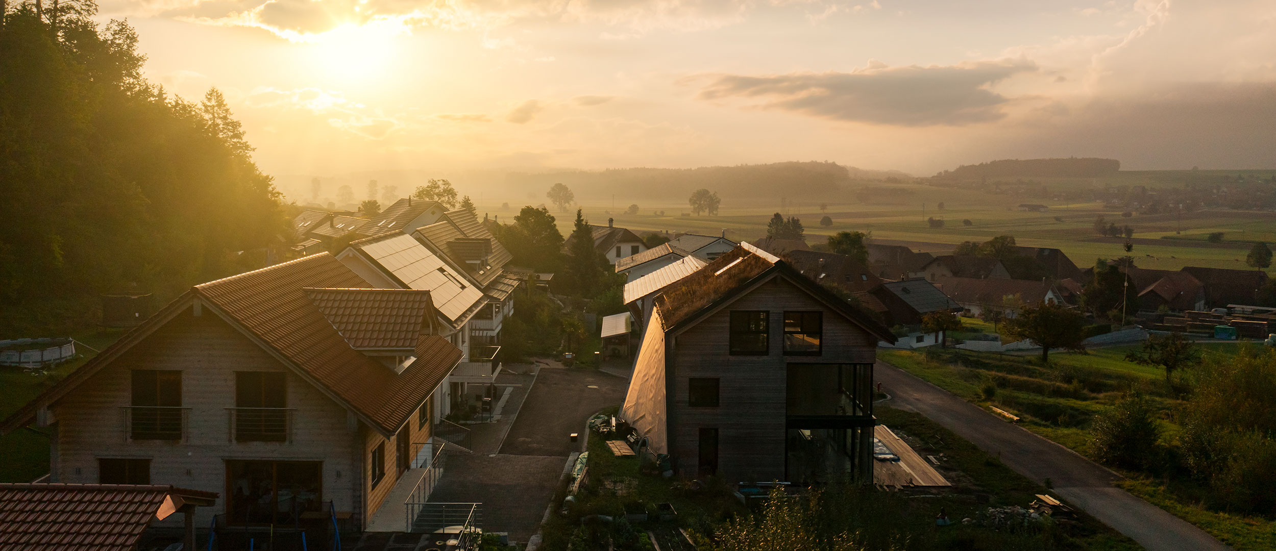 Die Sonne geht auf, Unterramsern erwacht zum Leben. Auf den Dächern im Quartier hat es bereits einige Solaranlagen, viele davon gebaut mit der Genossenschaft Elektra als Partnerin.