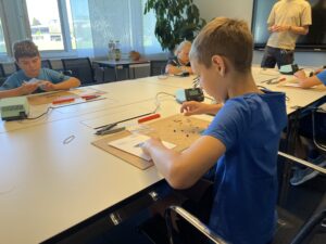 Nachdem die Kinder geprüft haben, ob ihr Bausatz komplett ist, werfen sie einen Blick in die Bauanleitung.