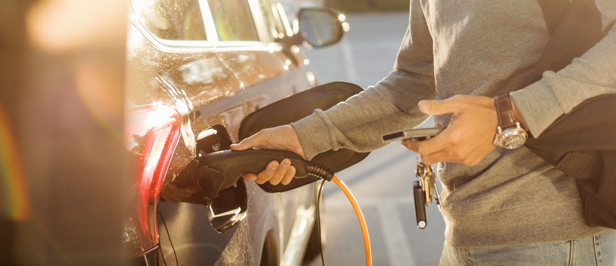 Ein Mann lädt sein Elektroauto.